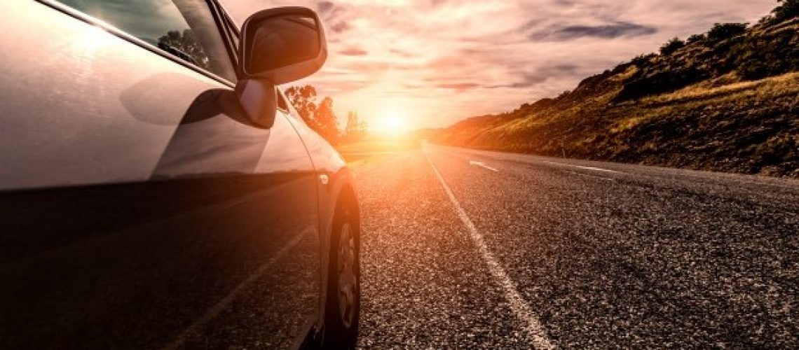 Car with sunset on the horizon